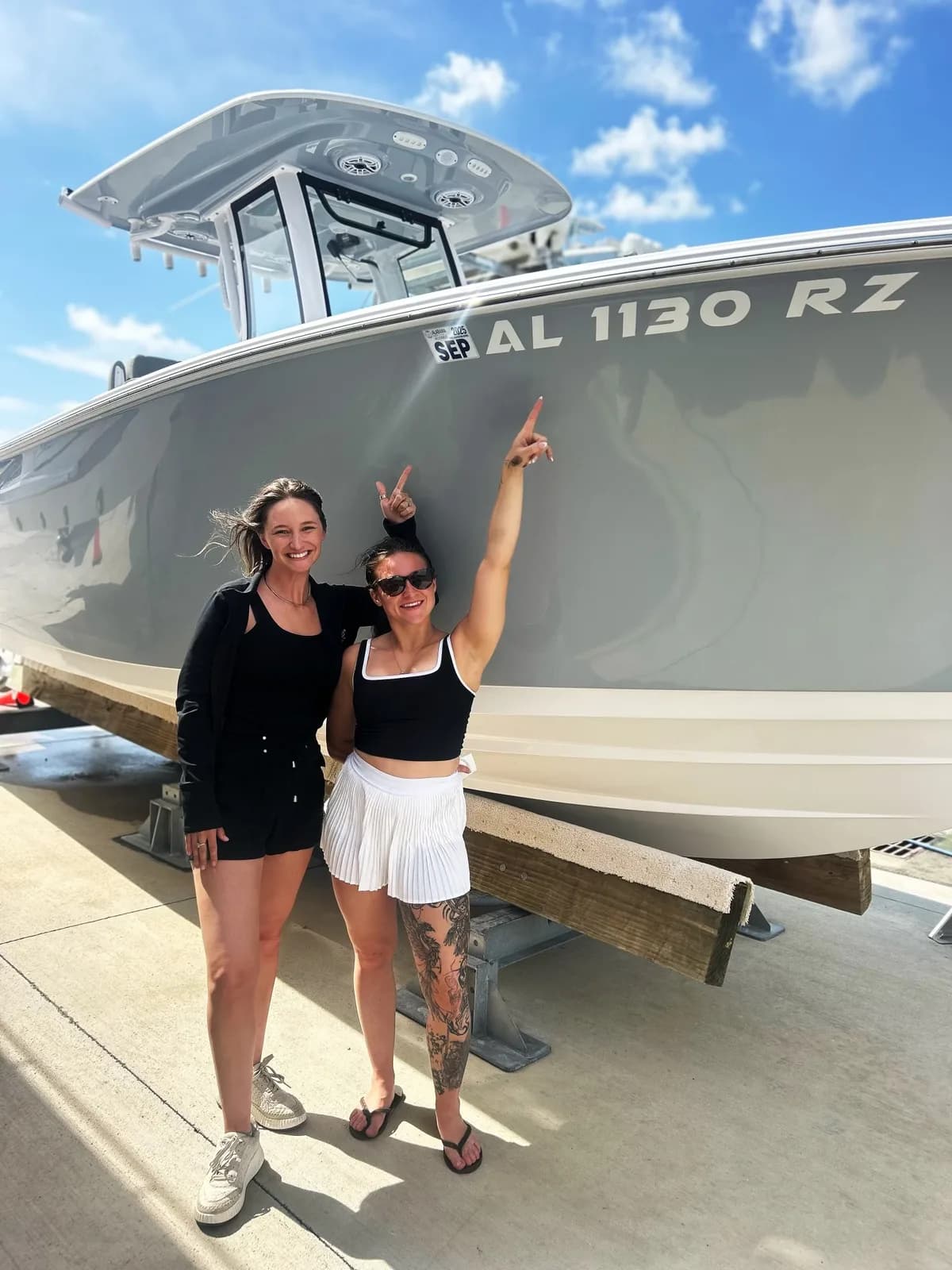The Vinyl Sisters team in front of a custom-lettered boat